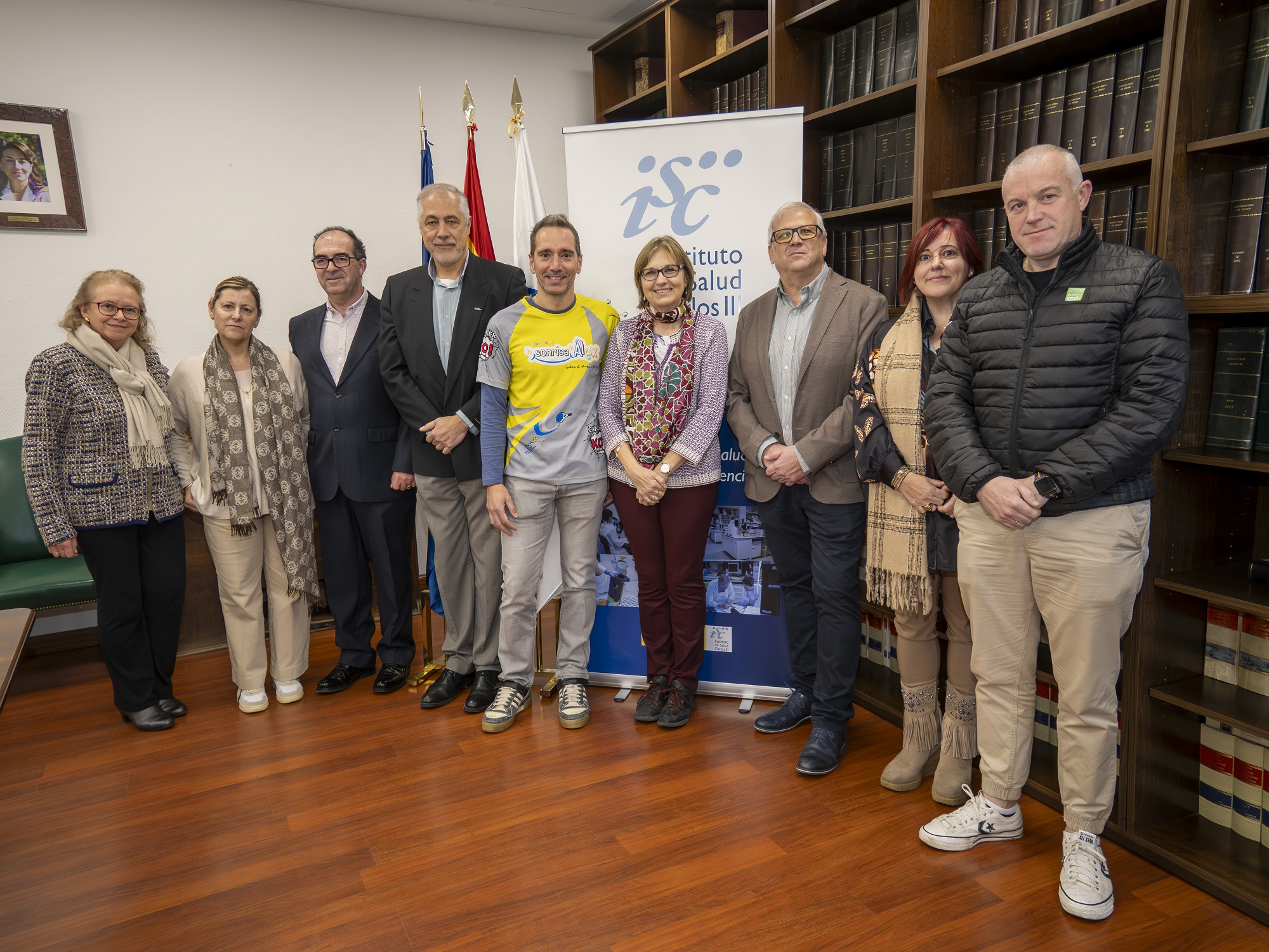 La directora del ISCIII, Marina Pollán (sexta por la izquierda), con el presidente de Sonrisa de Alex, Javier Carrasco (a su derecha), y la presidenta de Todos somos Iván, María José Pellón (segunda por la derecha), tras la firma del acuerdo de voluntades entre ambas partes. Les acompañan Eva Bermejo, directora del IIER-ISCIII (primera por la izquierda), el subdirector del Instituto Miguel Calero (cuarto por la izquierda), el investigador del IIER-ISCIII Javier Alonso (tercero por la derecha) y más representantes de las citadas asociaciones.